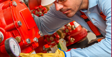 Technician servicing fire protection equipment