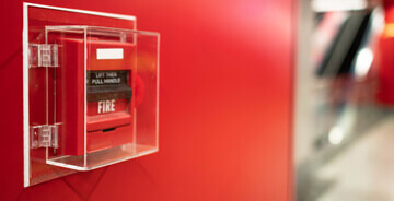 Fire alarm enclosed on the wall in a clear box